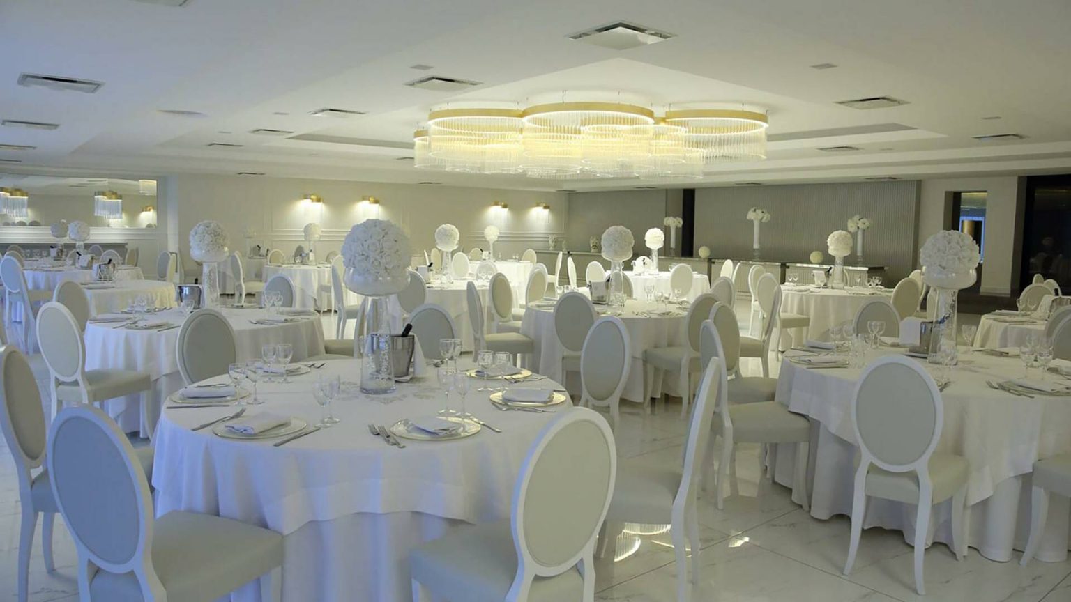 Sala Roberta: tavoli bianchi apparecchiati sotto un soffitto di punti luce dorati